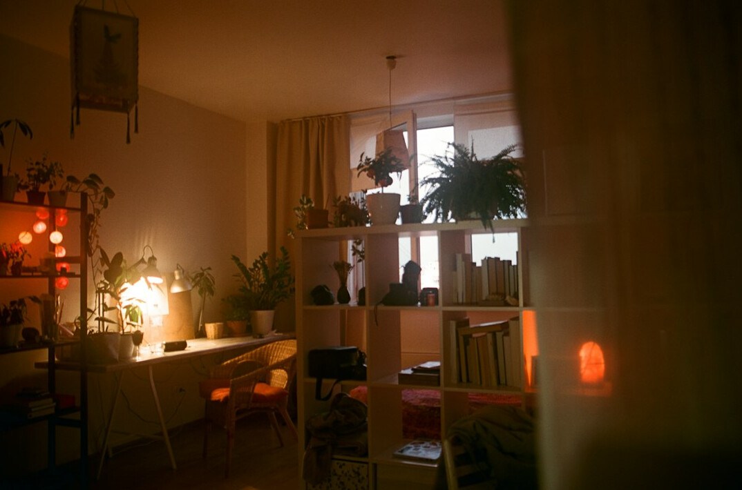 Cozy home workspace with a laptop, notebook and warm desk lamp at night