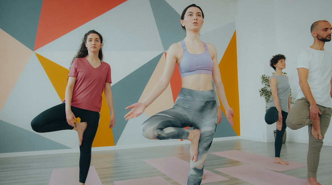 Group of diverse people practicing yoga together in a bright studio